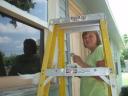 Wanda Rice painting the backside of the parsonage.